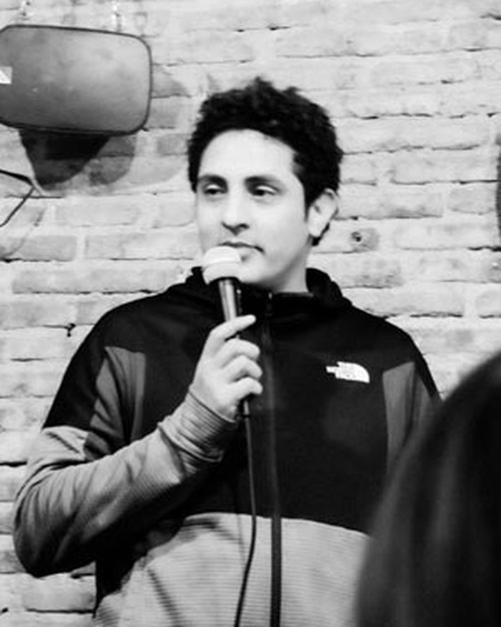 Mehdi Mahtaj performing stand-up with a microphone
