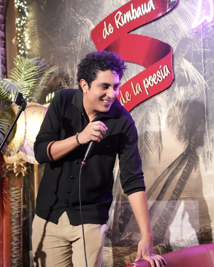 Mehdi Mahtaj smiling on stage with a microphone