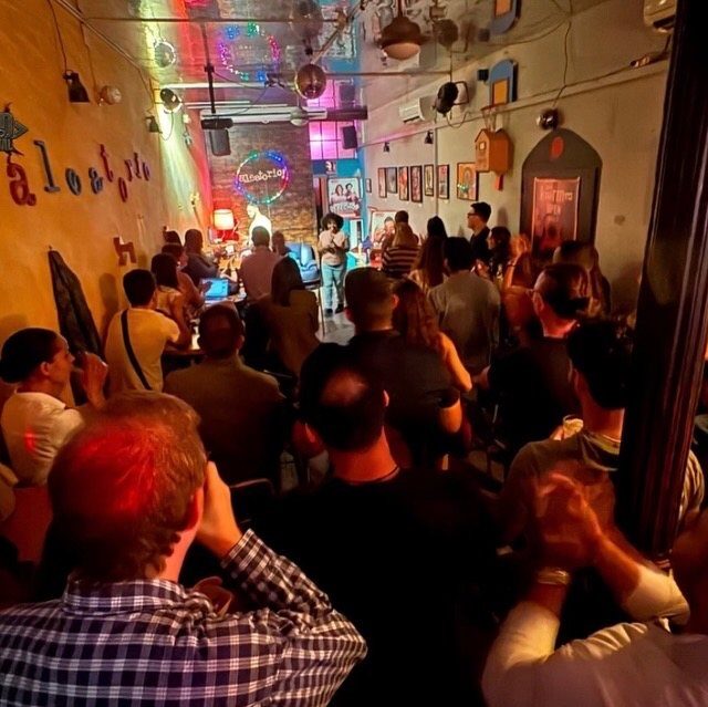 A packed room watching a No Offense, But... show