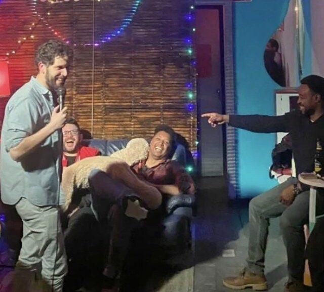 Comedian on stage talking to the crowd at a No Offense, But... show